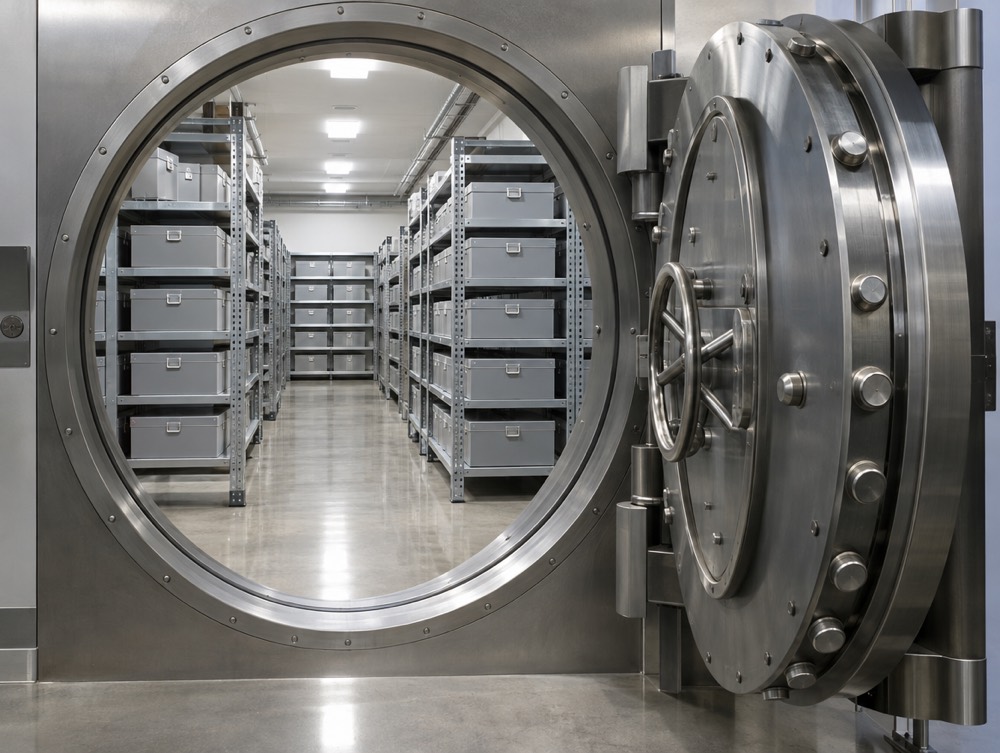 Open vault door in front of a secure storage room with shelving
